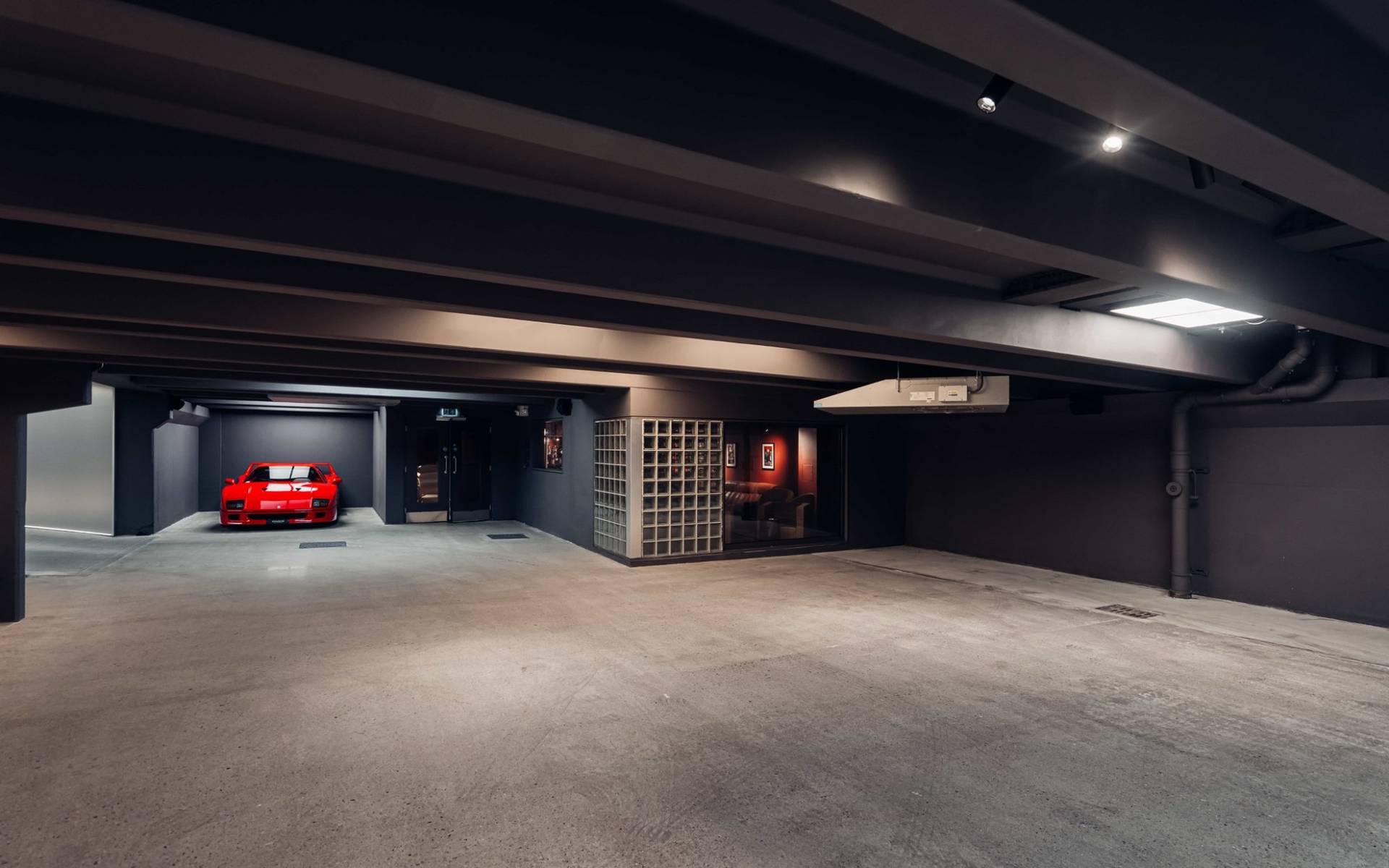 Corner view of an underground bunker filming venue with glass block partition walls and dark industrial finishes in Brentford TW8 through Love Locations.