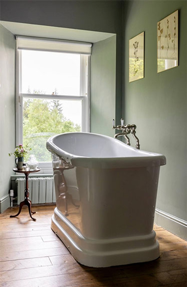 Glenstriven free-standing bath by a large window overlooking woodland at the historic country house.