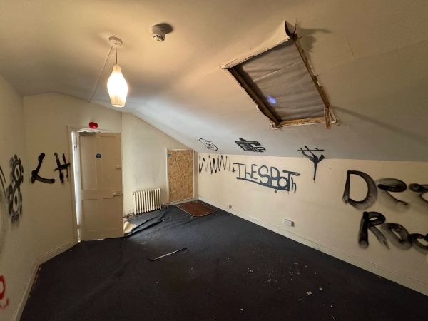 Dilapidated attic room space showing a large rectangular hole cut or collapsed out of the ceiling plaster, Love Locations.