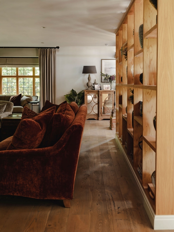 Cozy reading nook corridor featuring a plush burgundy armchair and warm timber flooring, Love Locations.