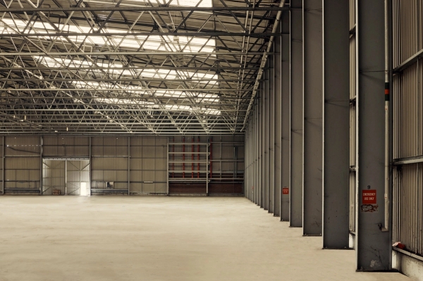 Derelict industrial warehouse property featuring a long row of steel structural columns, suitable for music video locations, Love Locations SE8.
