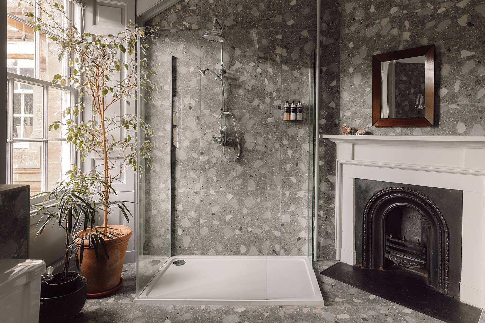 Walk-in shower room with grey patterned wallpaper, glass screen, and period fireplace, Love Locations KY15.