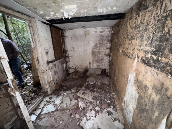 Heavily distressed room with decaying plaster walls and an exposed dark timber beam, ideal as a gritty drama shoot space through Love Locations.