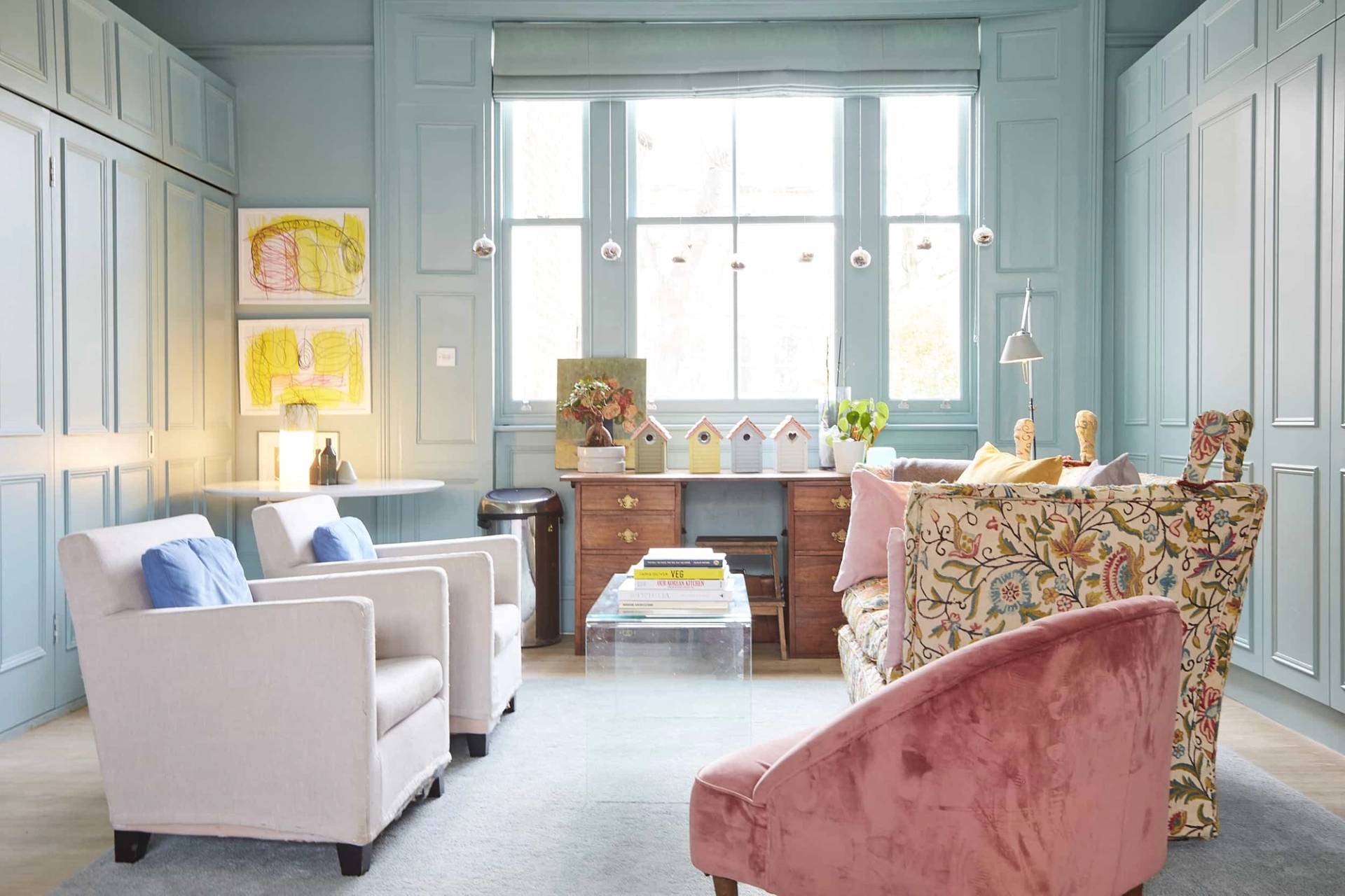 Classic period reception room featuring duck-egg blue panelled walls, sash windows, pink velvet armchair, and glass coffee table, Love Locations.