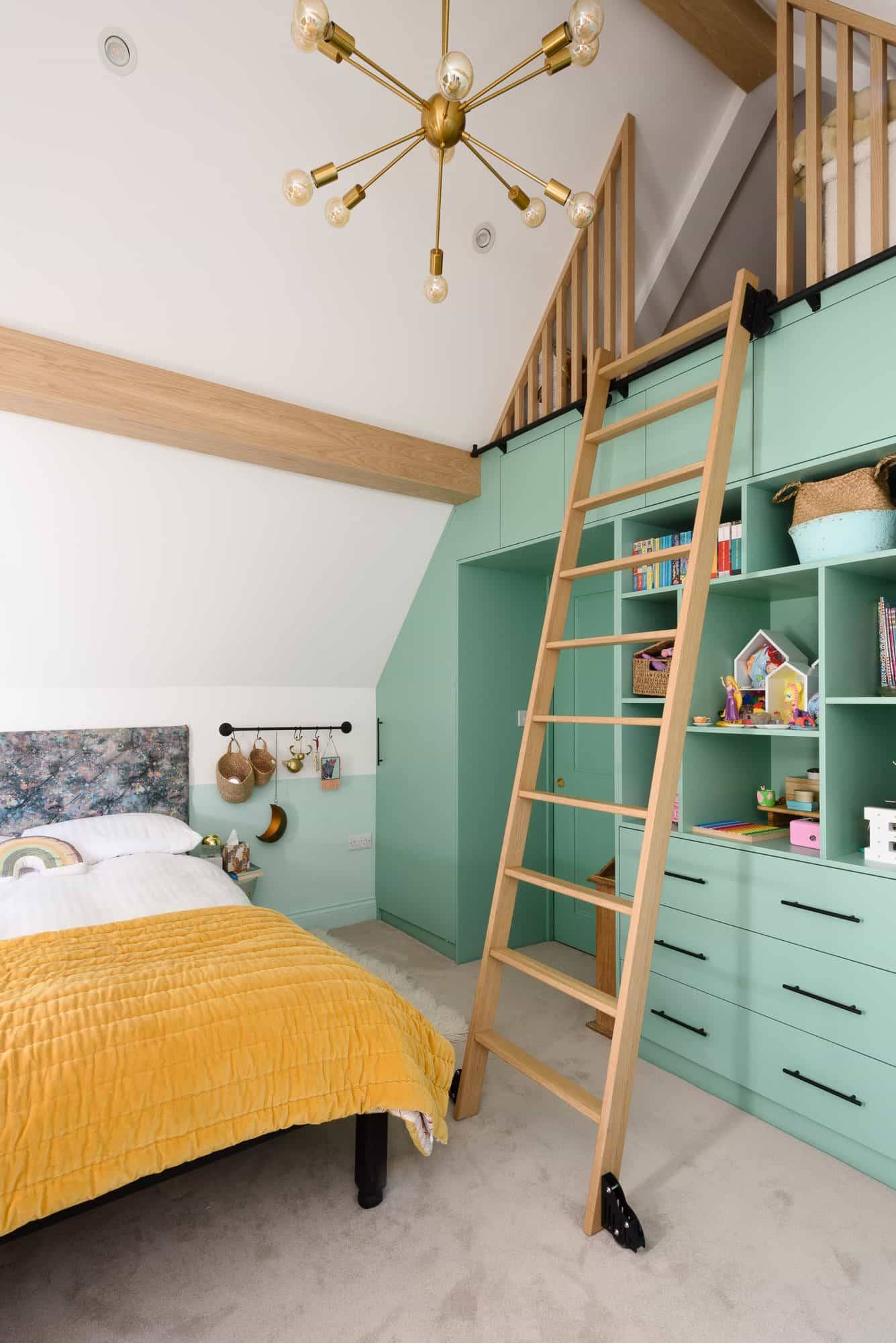 Kids attic bedroom featuring a sage green loft bed structure with wooden climbing ladder, Love Locations TW11.