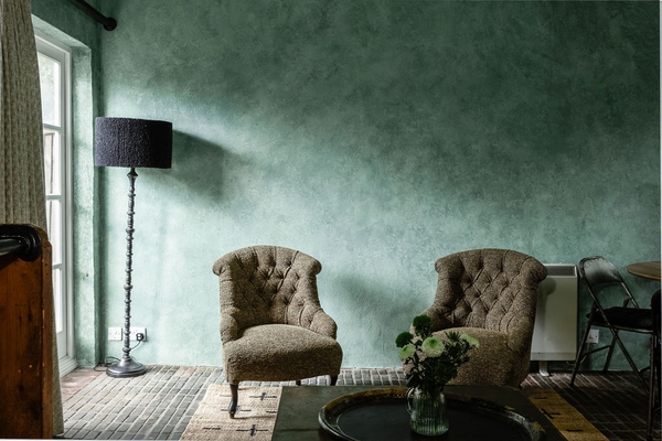 Moody interior with green walls, vintage armchairs and atmospheric lighting at Love Locations, Liss, Hampshire GU33.