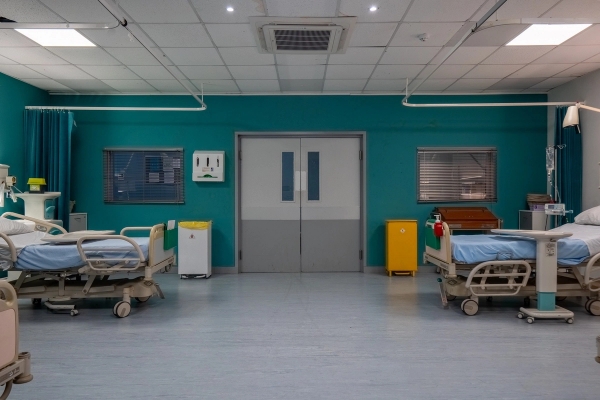 Wide hospital ward bay with double doors, medical equipment, and hospital beds, Love Locations UB4.