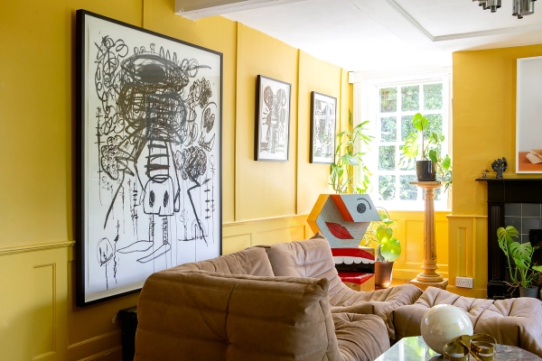 Eclectic yellow lounge featuring large abstract wall art, tan velvet couch, and wall panelling, Love Locations ME13.