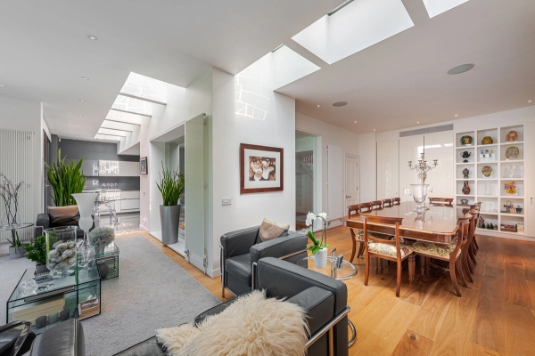 Contemporary split-level living space showcasing a dark leather sofa and architectural roof glazing, suitable for high-end editorial shoots, Love Locations W4.