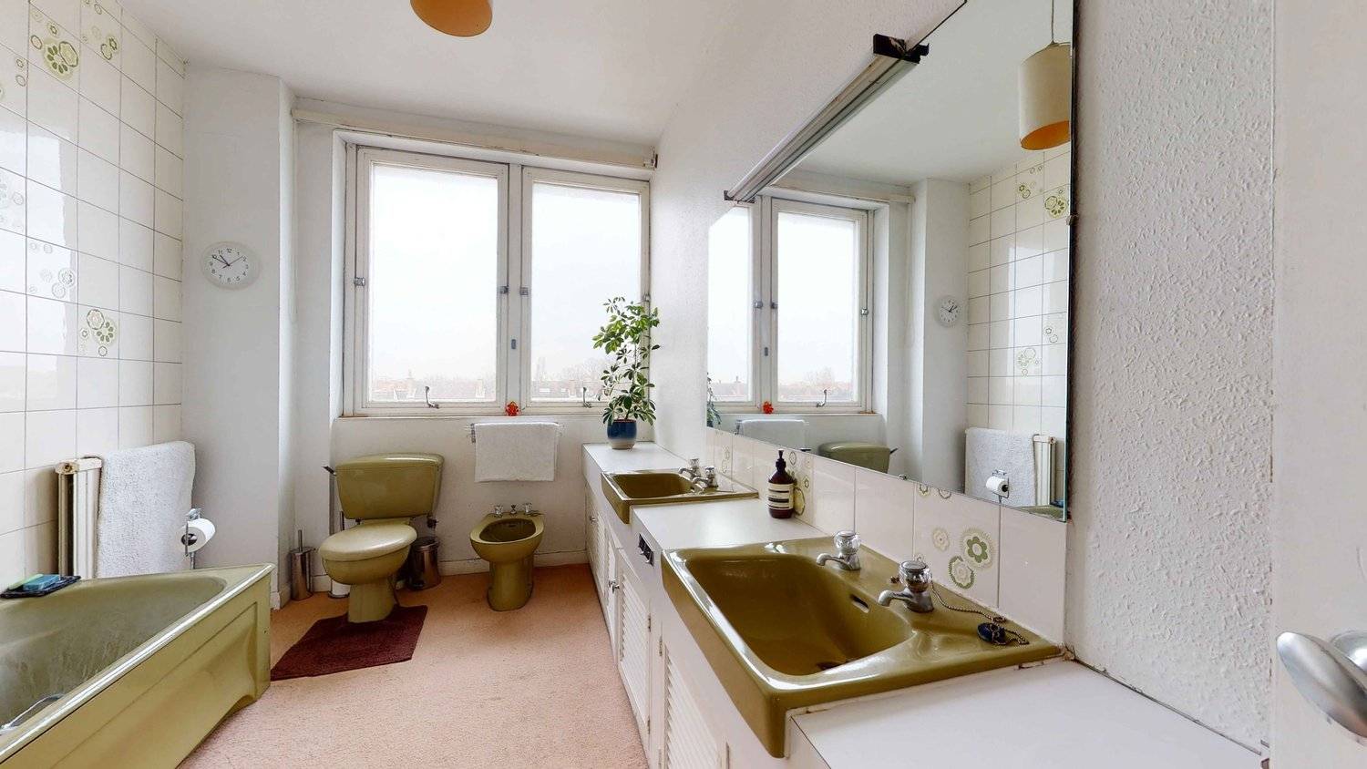 Vintage bathroom suite featuring an original avocado green toilet and double sink vanity with retro tiles, Love Locations SW16.