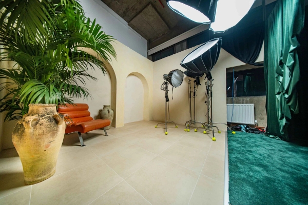 Studio production floor in Tottenham, N15 showing lighting equipment set up in front of a plaster arch set, Love Locations.