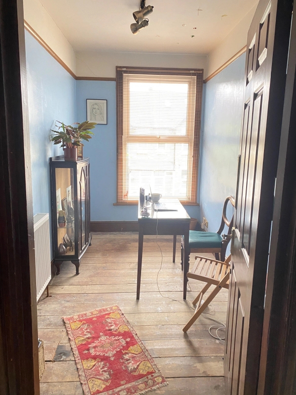 Quirky home study or writing room setup featuring blue walls, a minimalist wooden desk, and a retro display cabinet, ideal for creative brand content, Love Locations SE25.