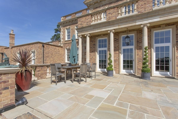 Luxury outdoor patio dining space with premium garden furniture overlooking the Sussex hills, bookable through Love Locations.