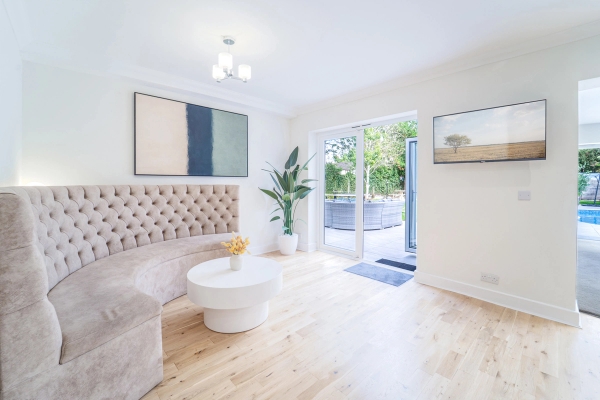 Sunlit reception seating area with cream upholstery, white round coffee table, and patio doors, Love Locations RM11.