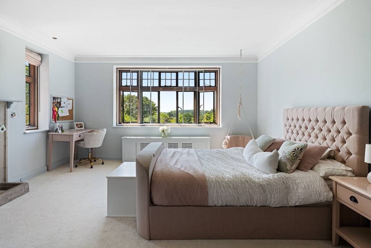 Secondary bedroom suite with a upholstered bed frame, soft neutral tones, and carpeted floors, Love Locations RH13.