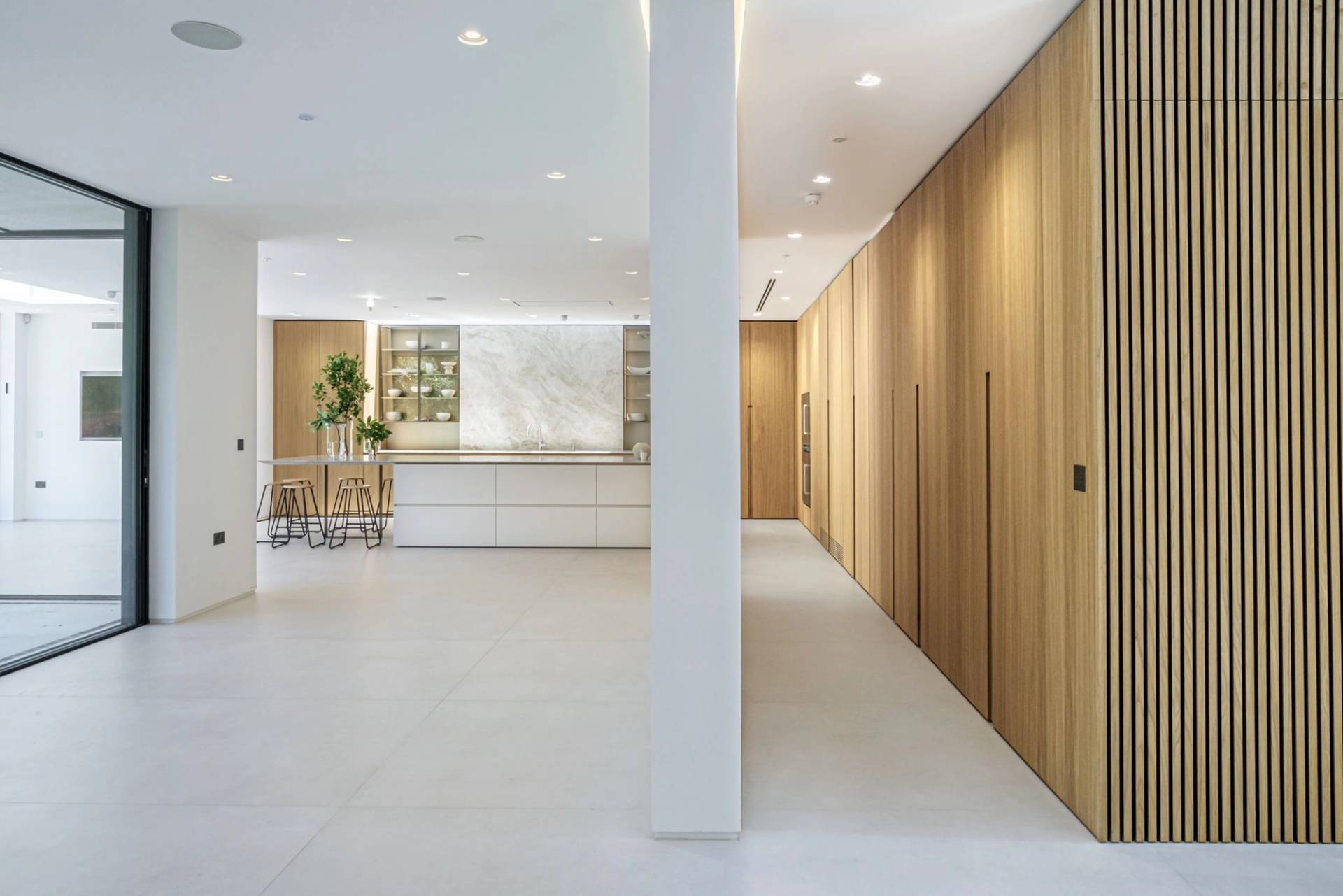 Modern luxury kitchen shoot location in Finchley Church End, N3 featuring full-height oak panelling, marble island, and recessed lighting, ideal for culinary commercials via Love Locations.