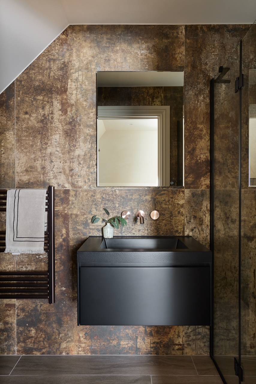 Industrial-chic bathroom backdrop showcasing metallic stone-textured walls and a sleek black washbasin, perfect for edgy fashion brand shoots, Love Locations WD23.
