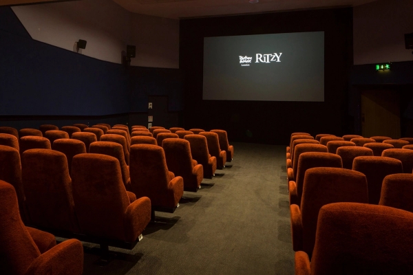 Angled perspective looking down the aisle toward the cinema screen in The Ritzy Screen 3 venue hire in Brixton SW2 through Love Locations.