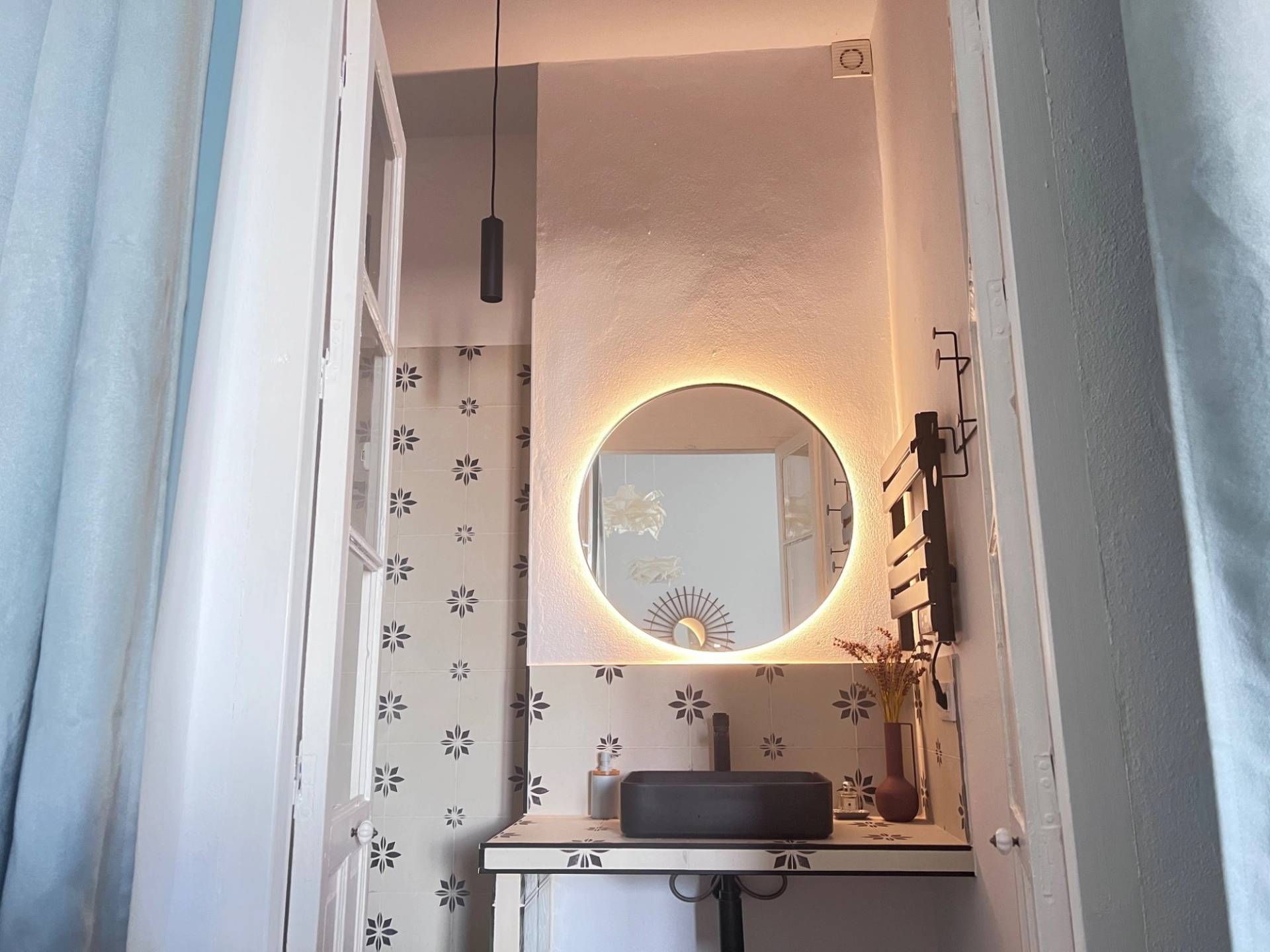 Modern vanity bathroom location in Jimena de la Frontera Cádiz from Love Locations, featuring a round illuminated mirror and sleek black fixtures.
