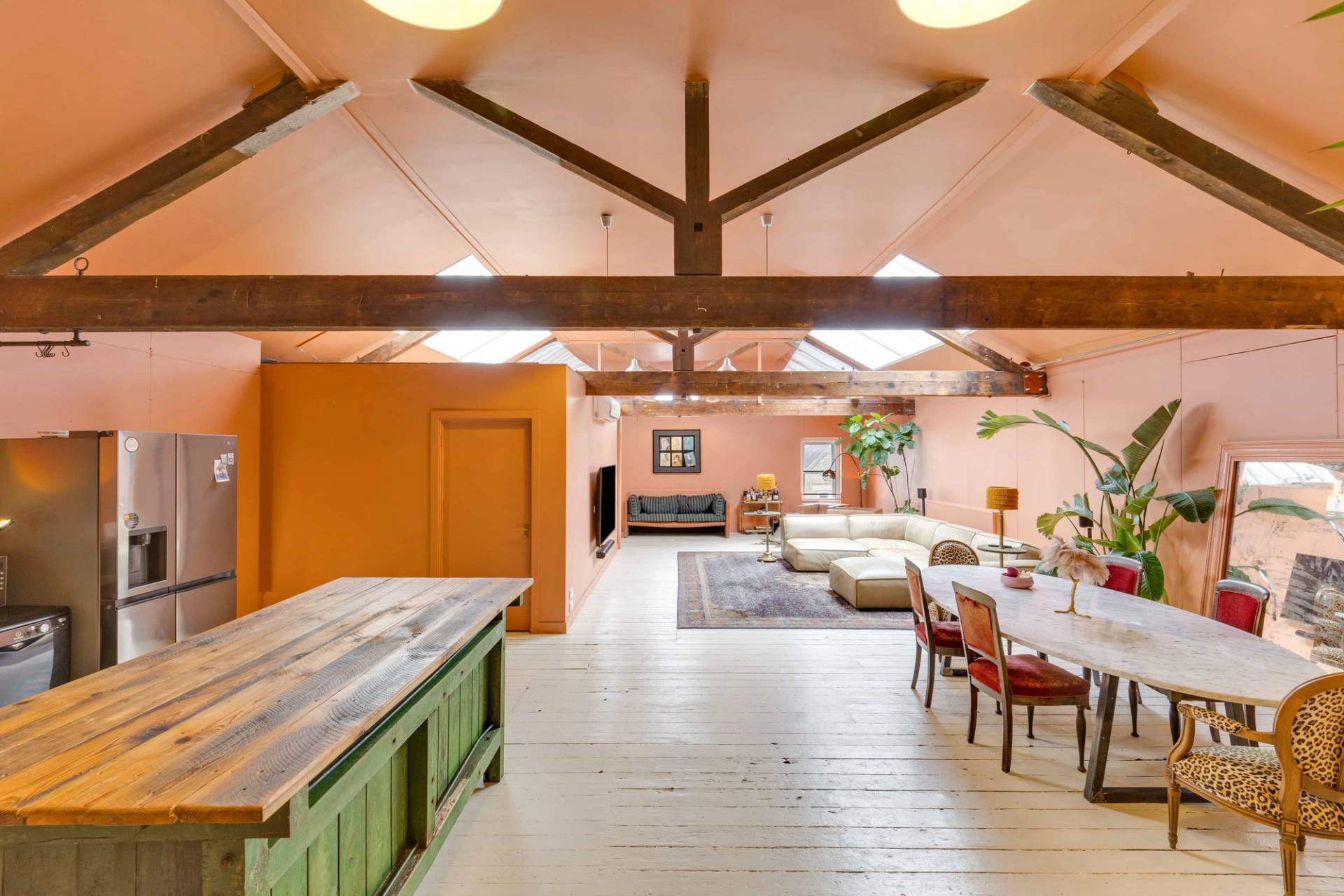 Bright creative location space with warm ambient lighting, exposed roof trusses, and white wooden floors, Love Locations.