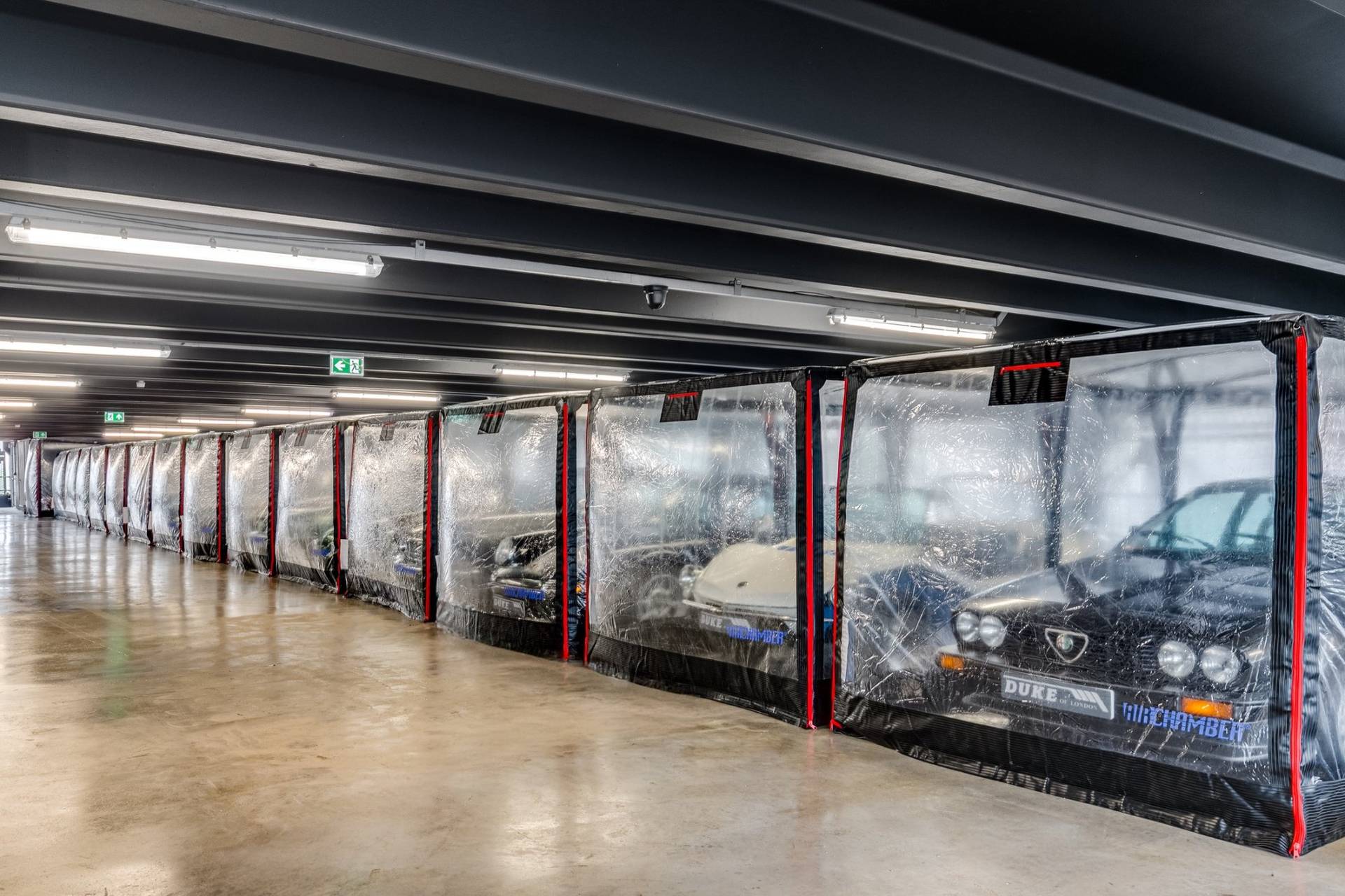 Climate-controlled car storage bay with clear protective bubbles in a West London factory location by Love Locations.