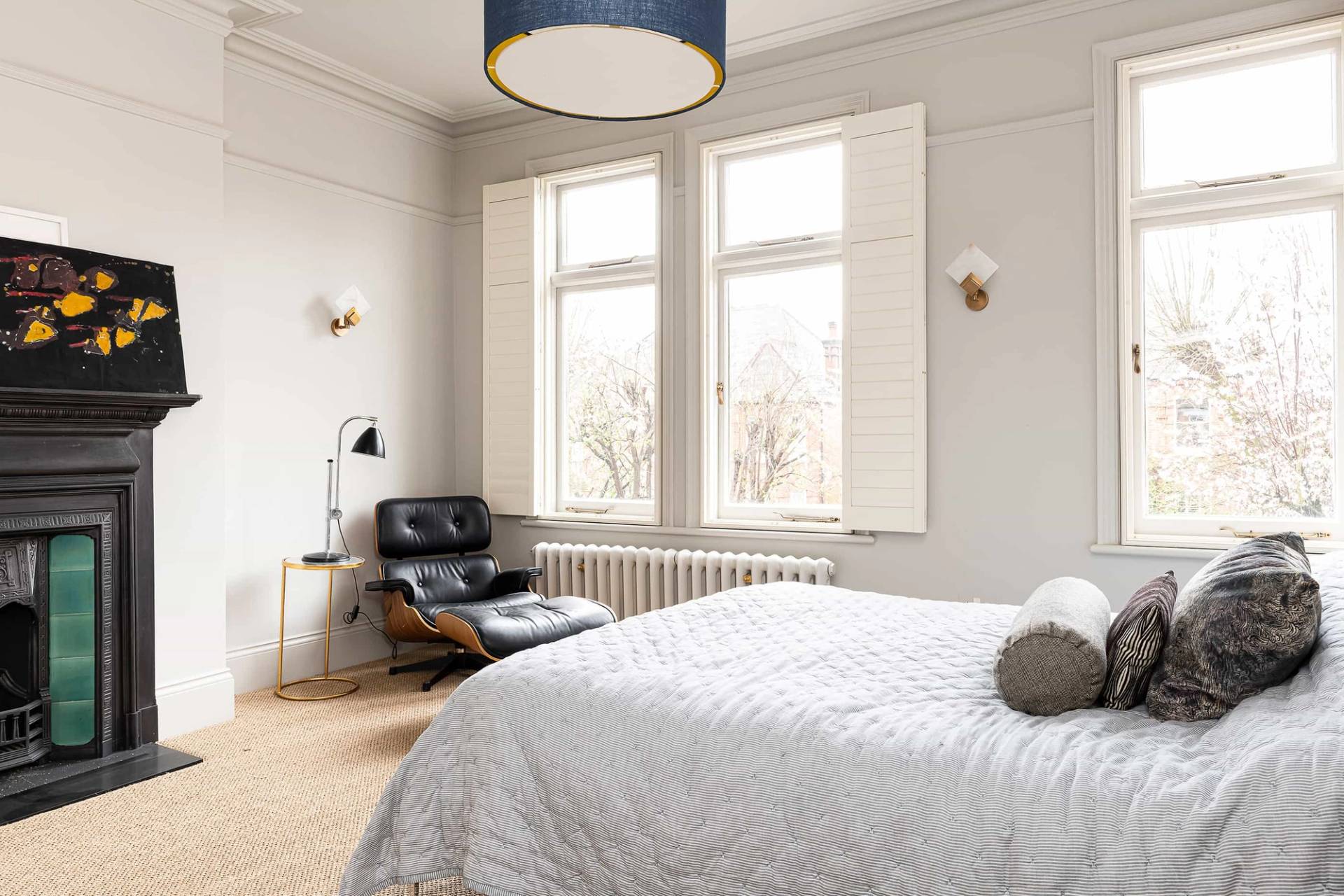 Secondary guest bedroom with grey walls, window shutters, and a black Eames lounge chair, ideal for bedding lookbooks, Love Locations NW6.