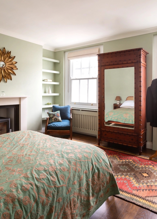 Elegant bedroom space for creative production hire in Westminster London SW1V by Love Locations, highlighting a large antique mirrored wardrobe, a fireplace, and a traditional sash window.