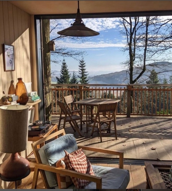 Outdoor balcony dining table and chairs overlooking panoramic rolling green hills and valley landscapes, premium setting for commercial shoots via Love Locations.