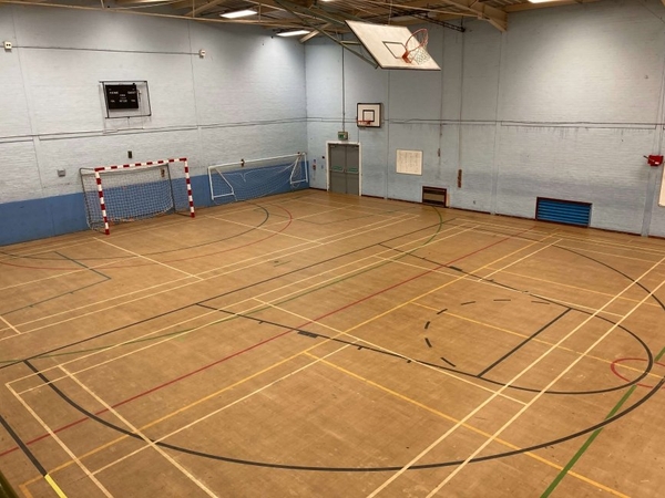 Love Locations school gymnasium shoot space Chelmsford: Large physical education hall with professional court markings and overhead lighting, tailored for athletic training videos and feature film sports scenes.