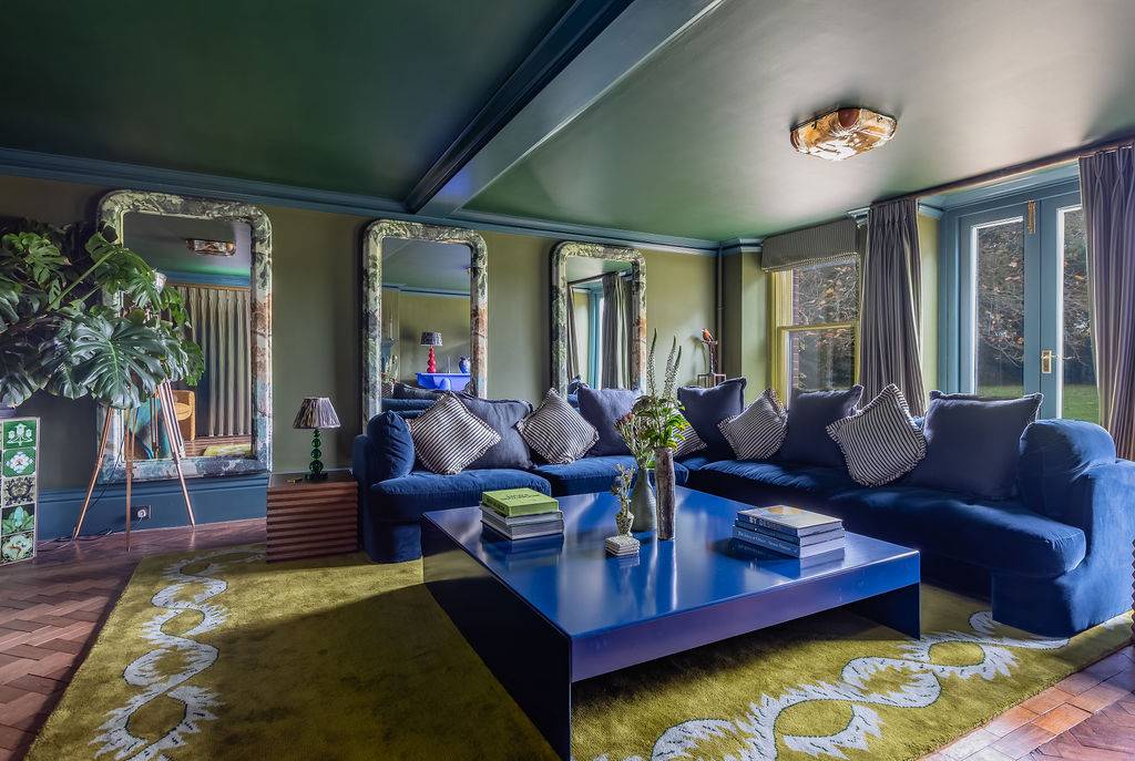 Expansive formal lounge film location in Liss Hampshire GU33 from Love Locations, spotlighting a large central cobalt blue coffee table and deep velvet seating.