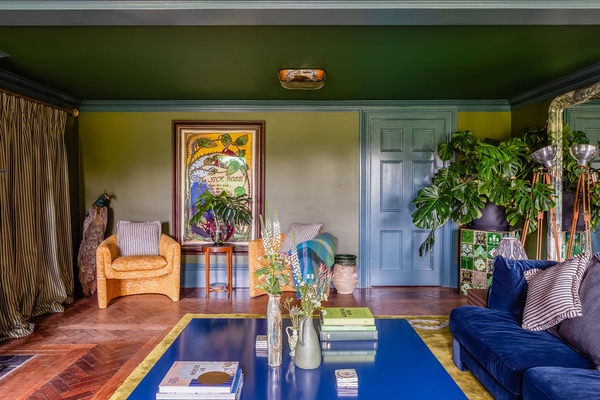 Open view across a grand blue-themed drawing room highlighting panelled doors and architectural symmetry, available via Love Locations.