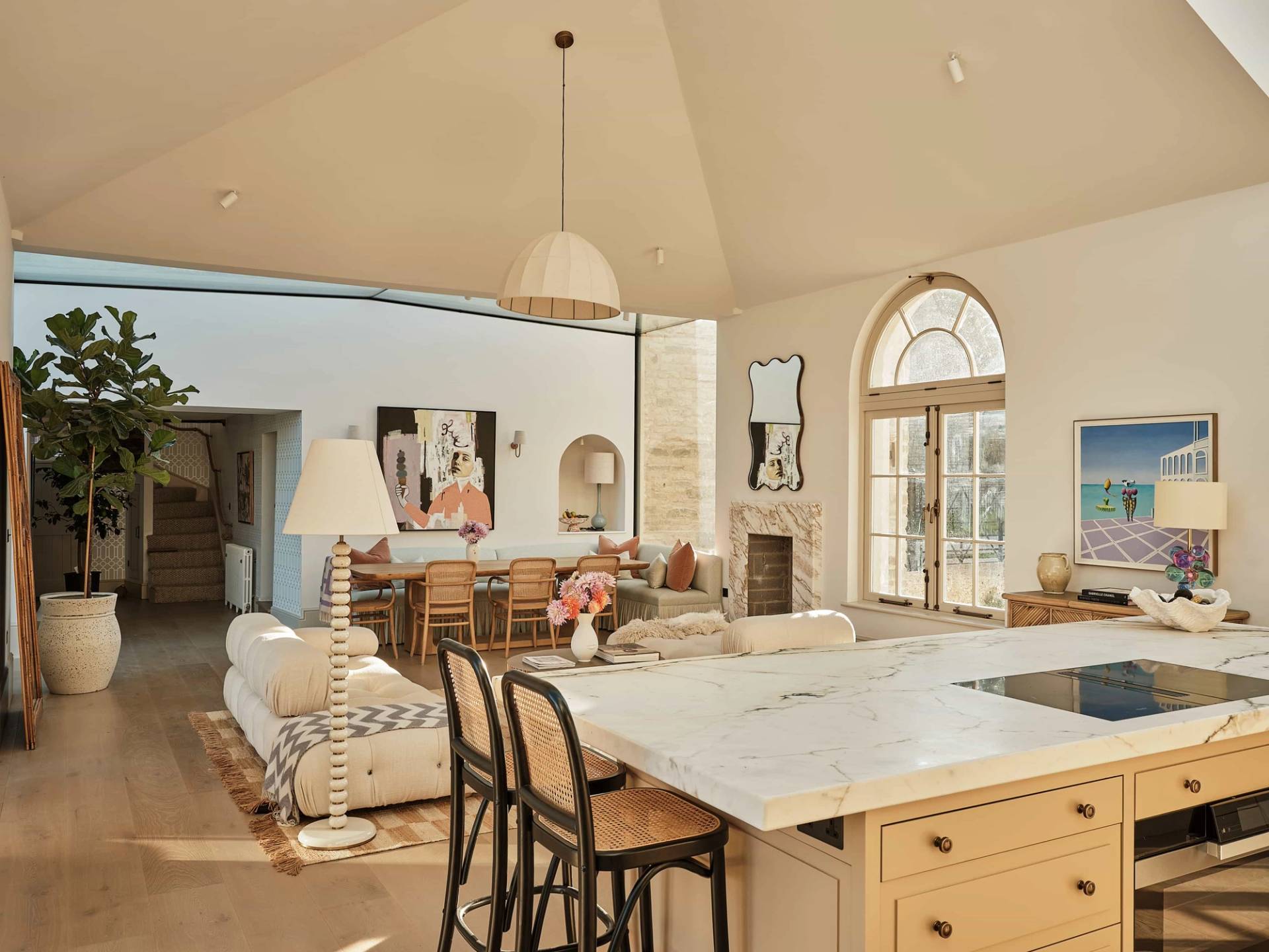 Wide-angle perspective from a marble kitchen island looking across a grand vaulted open-plan living room, perfect for film scene base setups, Love Locations.