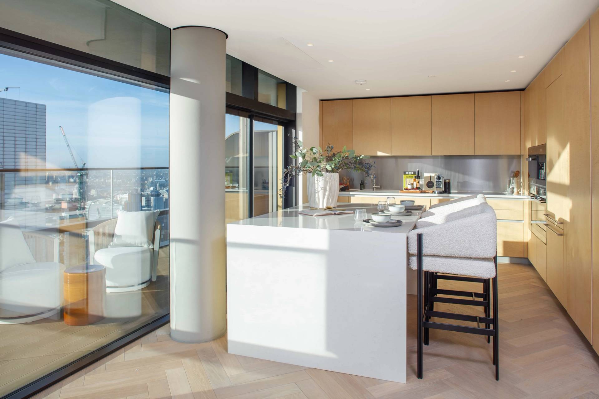 Modern penthouse kitchen workspace featuring built-in appliances, clean marble counters, and panoramic city backdrops, ideal for domestic brand ads, Love Locations.