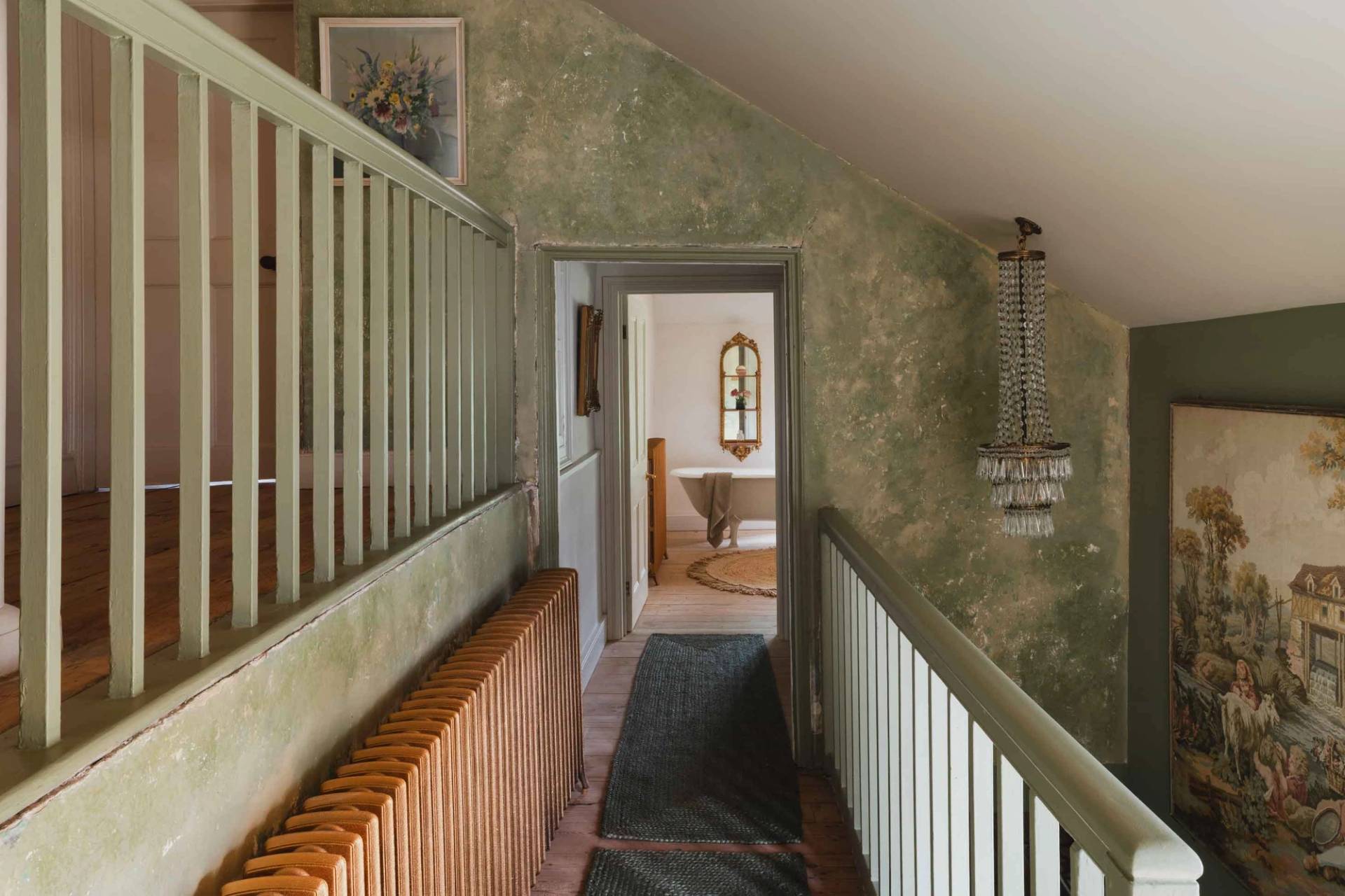 Characterful hallway with sage green lime-washed walls and vintage radiator in a Newquay location home from Love Locations.