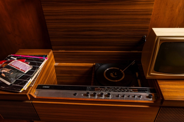 Vintage record player console built into dark wood cabinetry on a retro photography set, Love Locations N15.