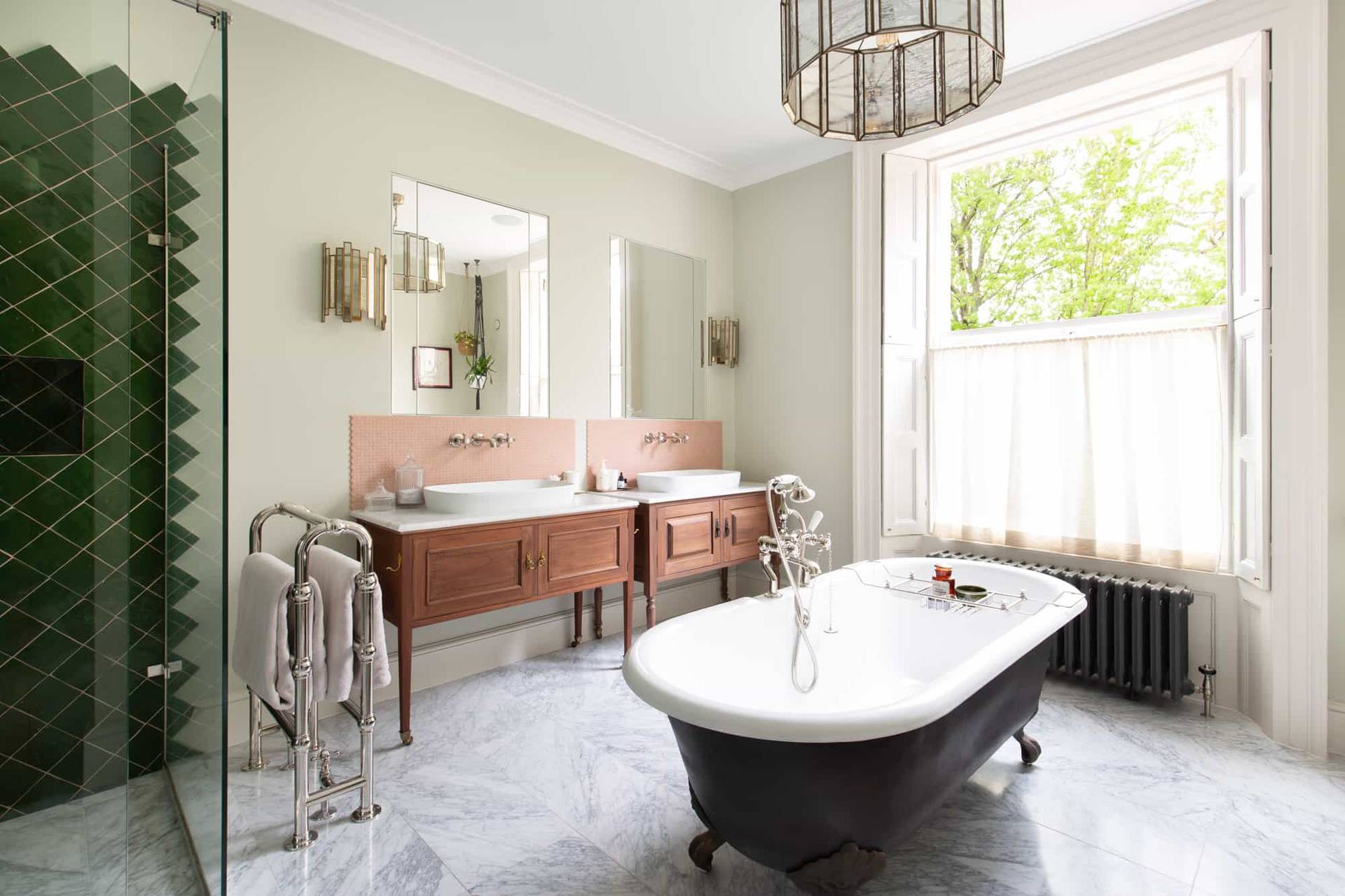Luxury bathroom in Camberwell, SE5 featuring freestanding black roll-top bath, marble vanity, and sage green walls via Love Locations.