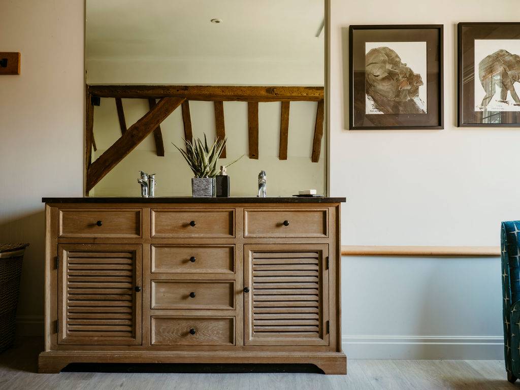 Double sink vanity unit with wooden louvred cabinetry and large frameless wall mirror, Love Locations.