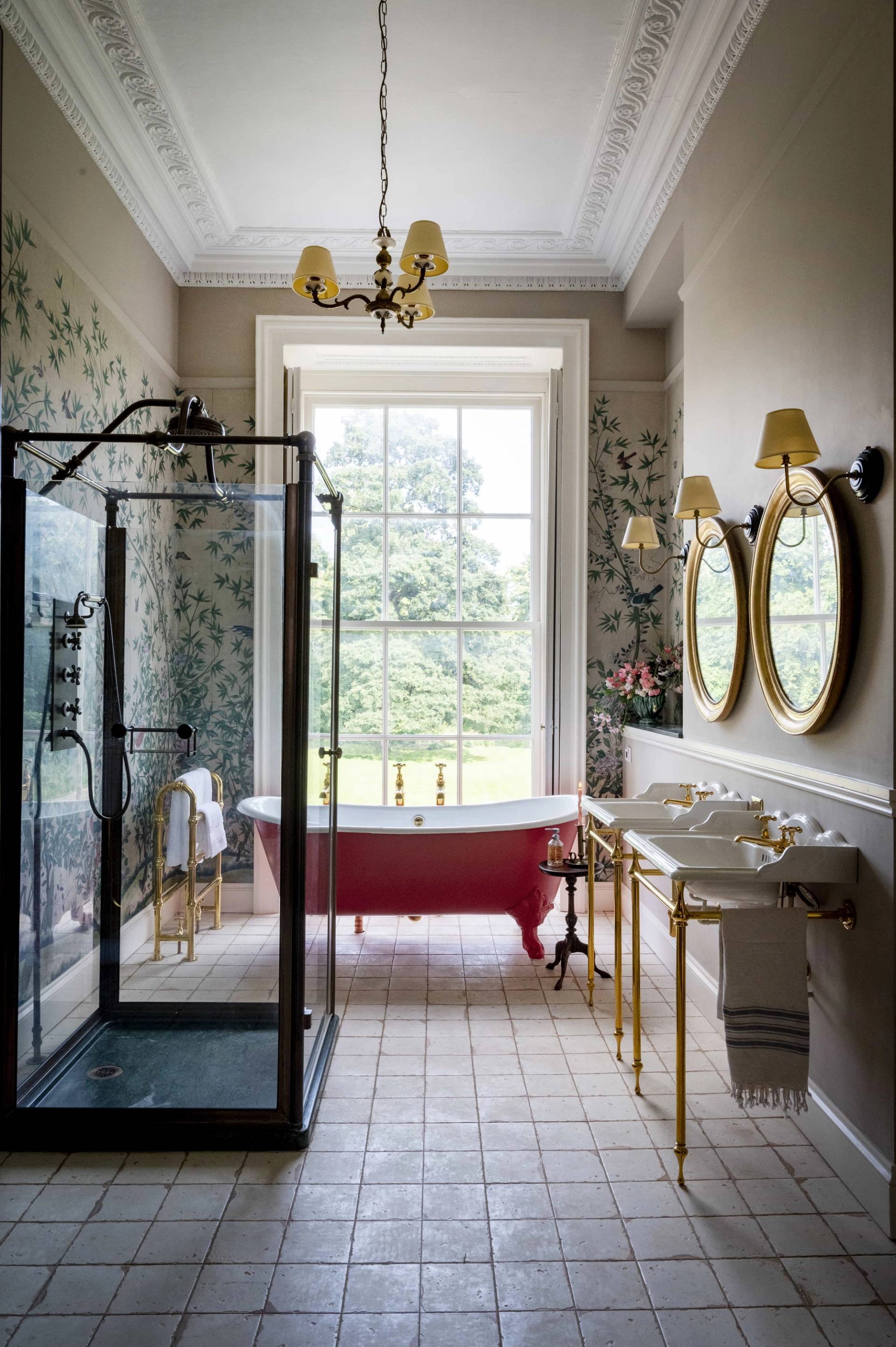 Luxury bathroom location featuring a red freestanding roll-top tub, walk-in shower, and brass washstand sinks, perfect for skincare brand campaigns via Love Locations LE7.
