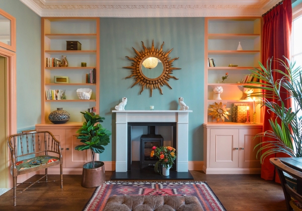 Period living room location in Westminster London SW1V for film and TV hire via Love Locations, featuring a white fireplace, a sunburst mirror, alcove cabinets, and a patterned rug.