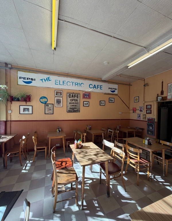 Vintage London cafe seating area with wooden dining furniture, retro overhead signage, and tiled floors for TV and film filming, Love Locations SE27.