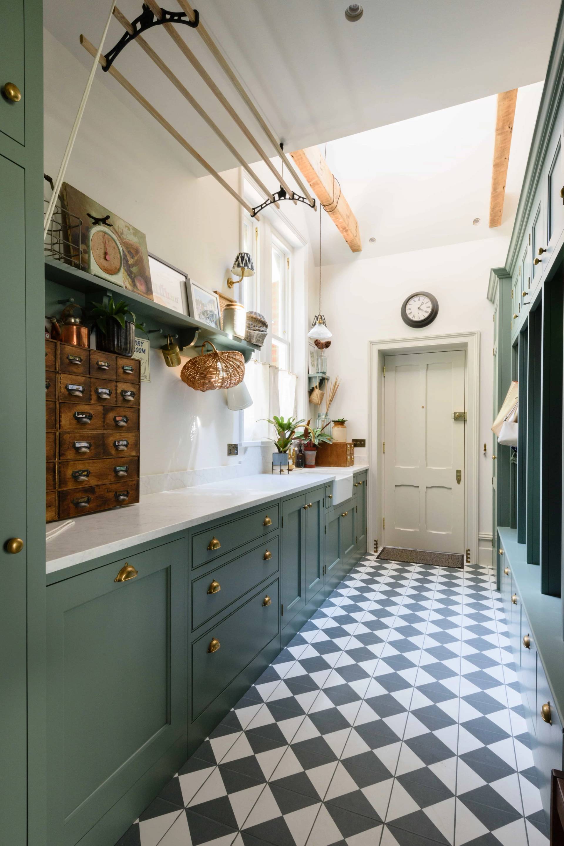 Utility room featuring forest green cabinets, black and white checkered floor tiles, and ceiling clothes airer, Love Locations TW11.
