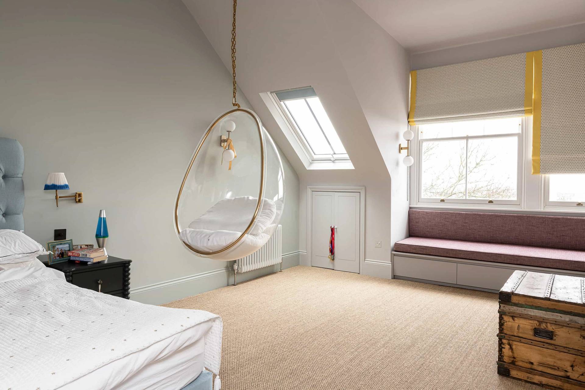 Top-floor bedroom with skylights, carpet flooring, and a hanging acrylic bubble chair, Love Locations.