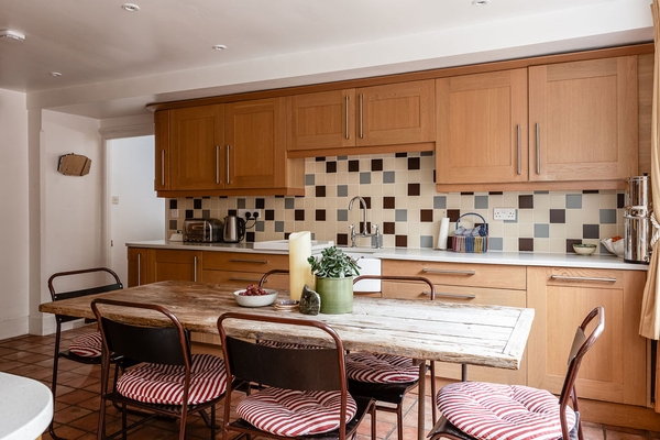 armhouse kitchen set showcasing checked tiling, wooden countertops, and integrated appliances, ideal for food brand photography by Love Locations.