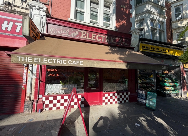 Classic red facade cafe exterior with retractable awning, storefront signage, and A-board chalkboard, Love Locations SE27.