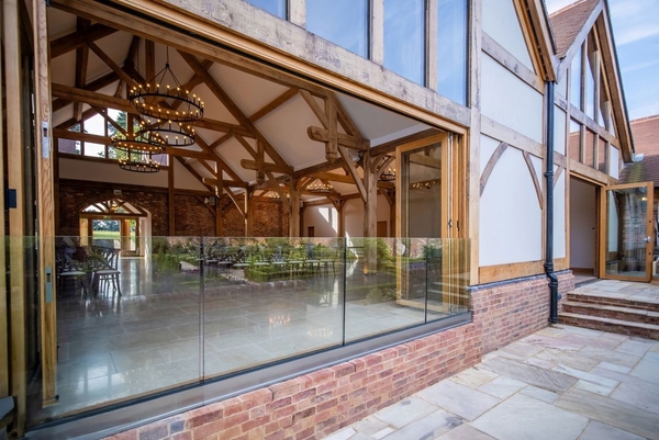 Modern converted barn venue with massive oak beams and glass bi-fold doors for Sussex weddings, managed by Love Locations.