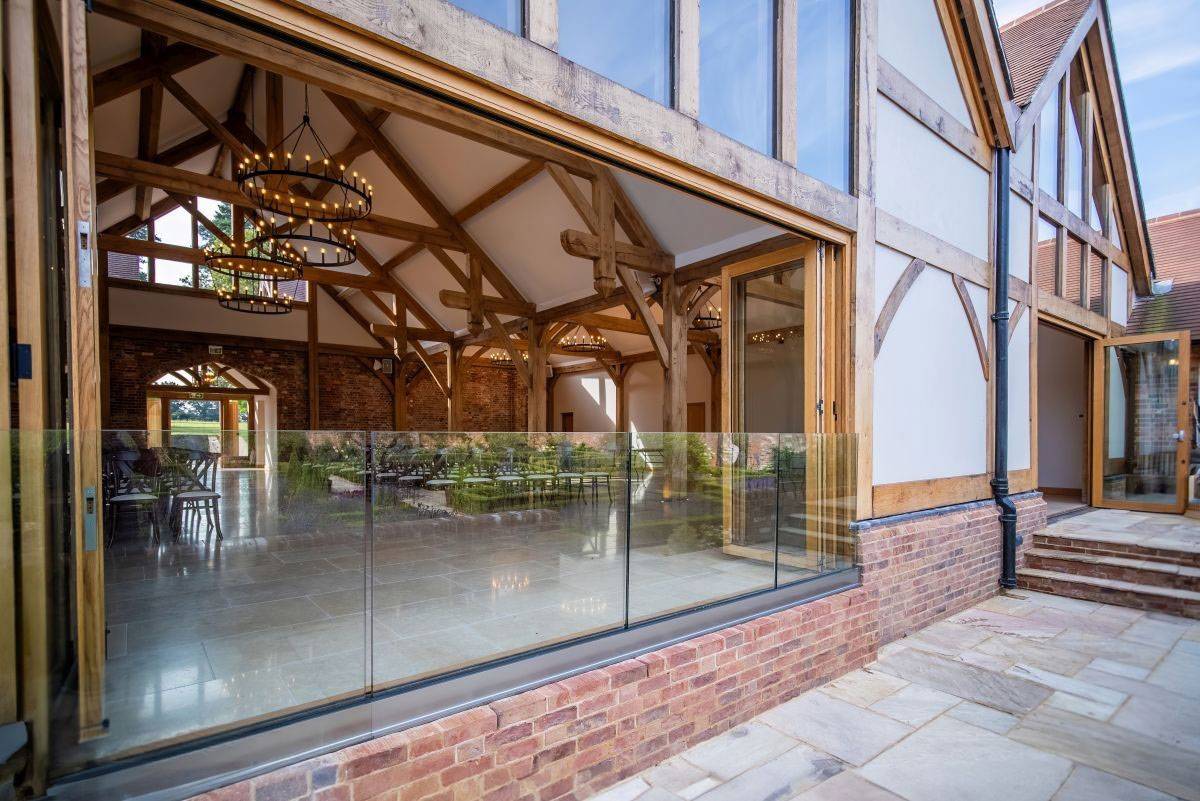 Modern converted barn venue with massive oak beams and glass bi-fold doors for Sussex weddings, managed by Love Locations.