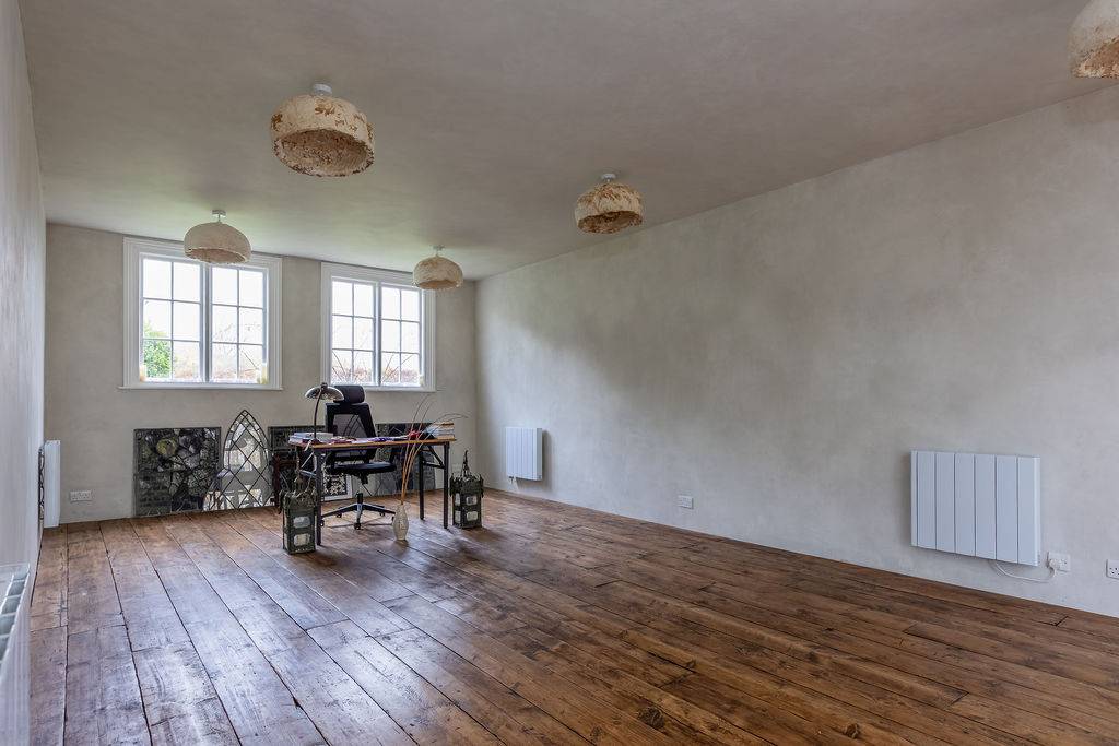 Open-plan studio room with timber flooring and large windows at Love Locations property in Liss, Hampshire GU33.