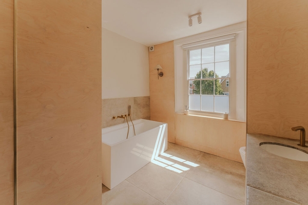 Stunning contemporary bathroom location featuring a freestanding white bathtub bathed in natural window light in Stockwell, SW9, Love Locations.