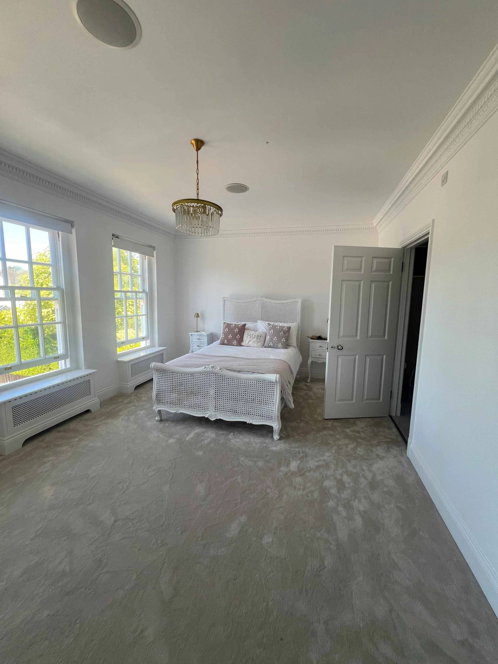 Guest bedroom suite with a white upholstered bed, grey carpets, and sash window light, Love Locations BR7.