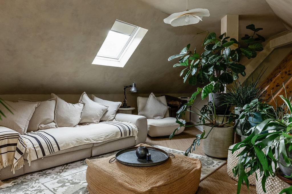 Relaxed attic sitting room with rooflight, soft furnishings and plants at Love Locations in Liss, Hampshire GU33.